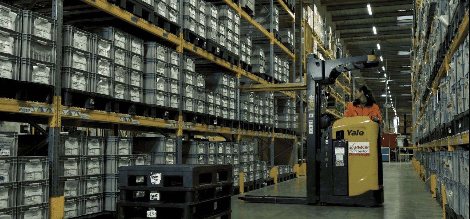 Magasinier en logistique industrielle préparant et stockant des pièces pour la production